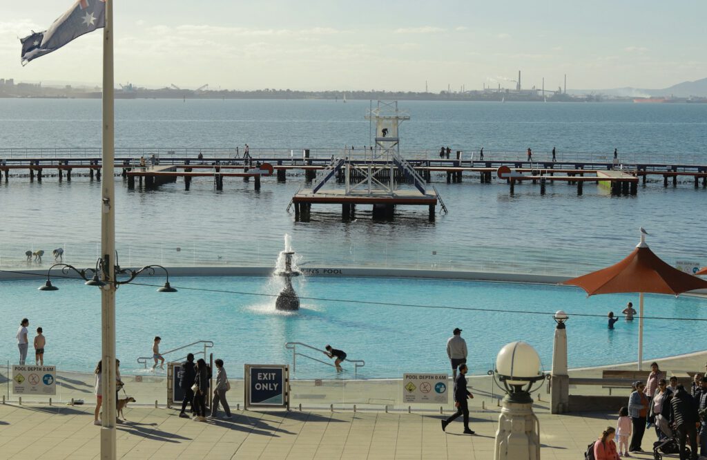 a group of people standing around a swimming pool